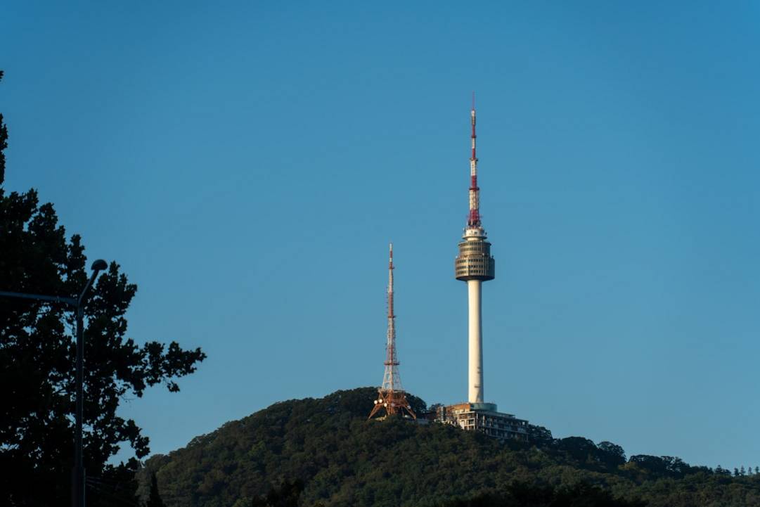 two towers on a forested hill under clear sky RpS3BEa606c