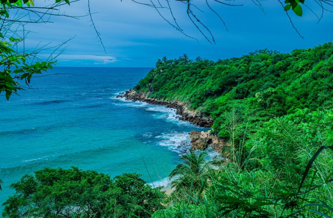 Sip a cold drink at a beach bar on Zipolite’s soft sand as the sun sets over the Pacific Ocean.