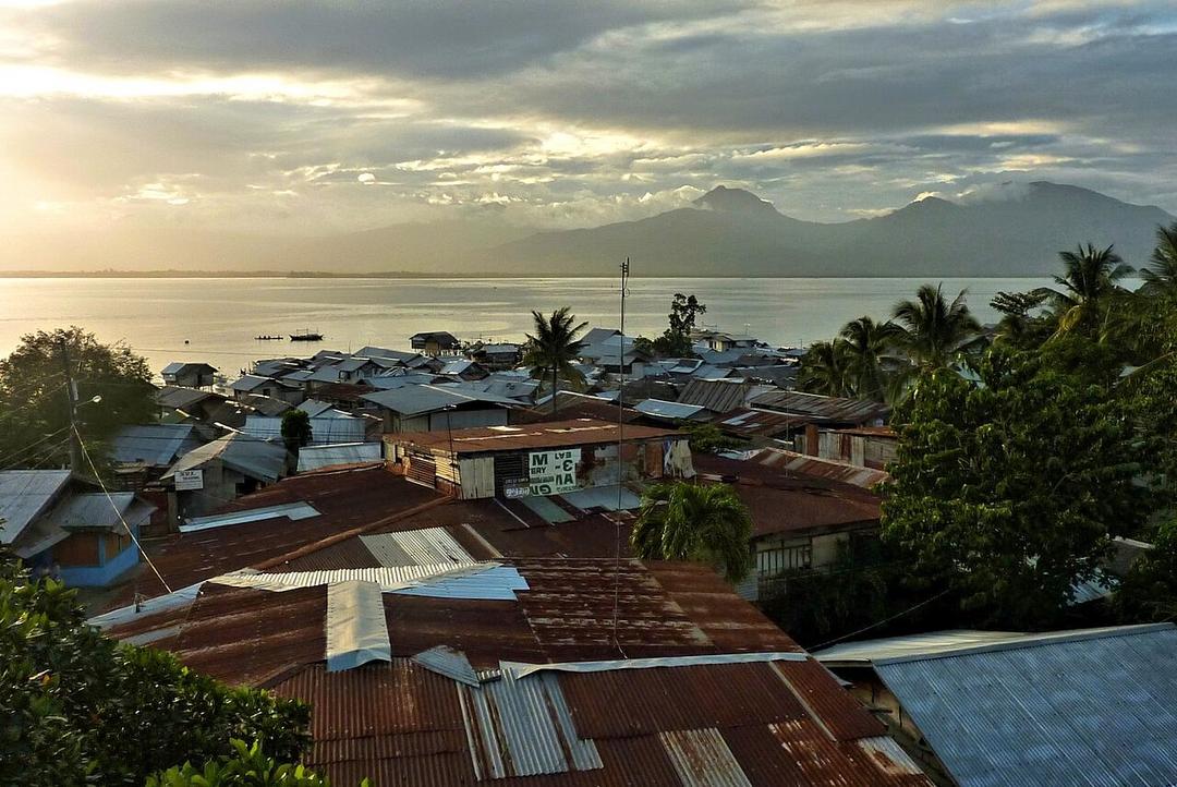 The salty tang of sea air mixes with the chatter of vendors at Puerto Princesa's San Jose Bay waterfront at dawn.