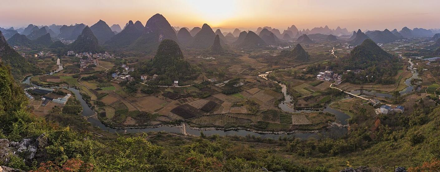 Top 11 activiteiten in Yangshuo: Li River, karstbergen en fietsen 3 Zonsopgang boven de Yulong-rivier bij Moon Hill, met mist die tussen de karstbergen hangt.